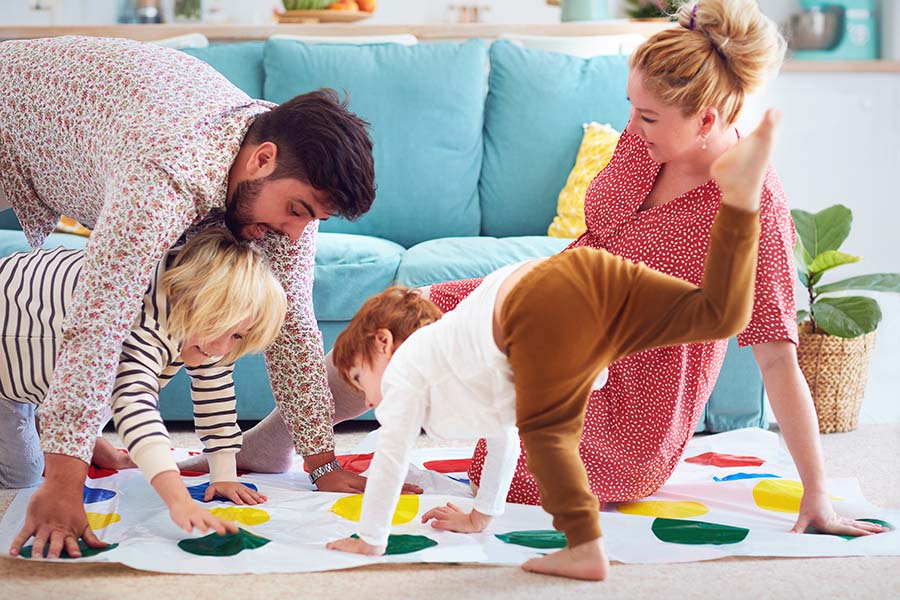 About Our Agency - View of a Happy Family Playing Twister Together with Their Two Kids in the Living Room
